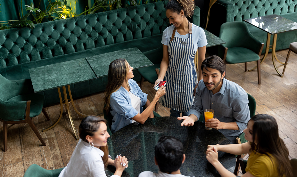 Woman paying by card at a restaurant. 