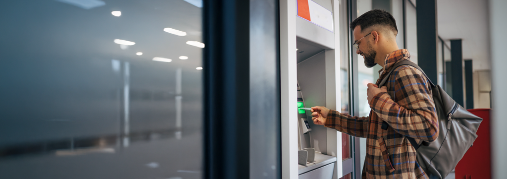 man inserting his debit card into an ATM