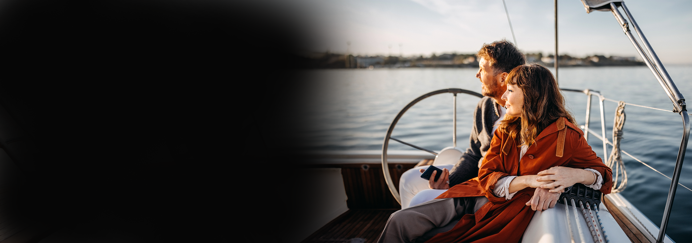 A couple sits on their boat, looking out at the water, after using PACU for their boat, RV, or motorcycle loan.
