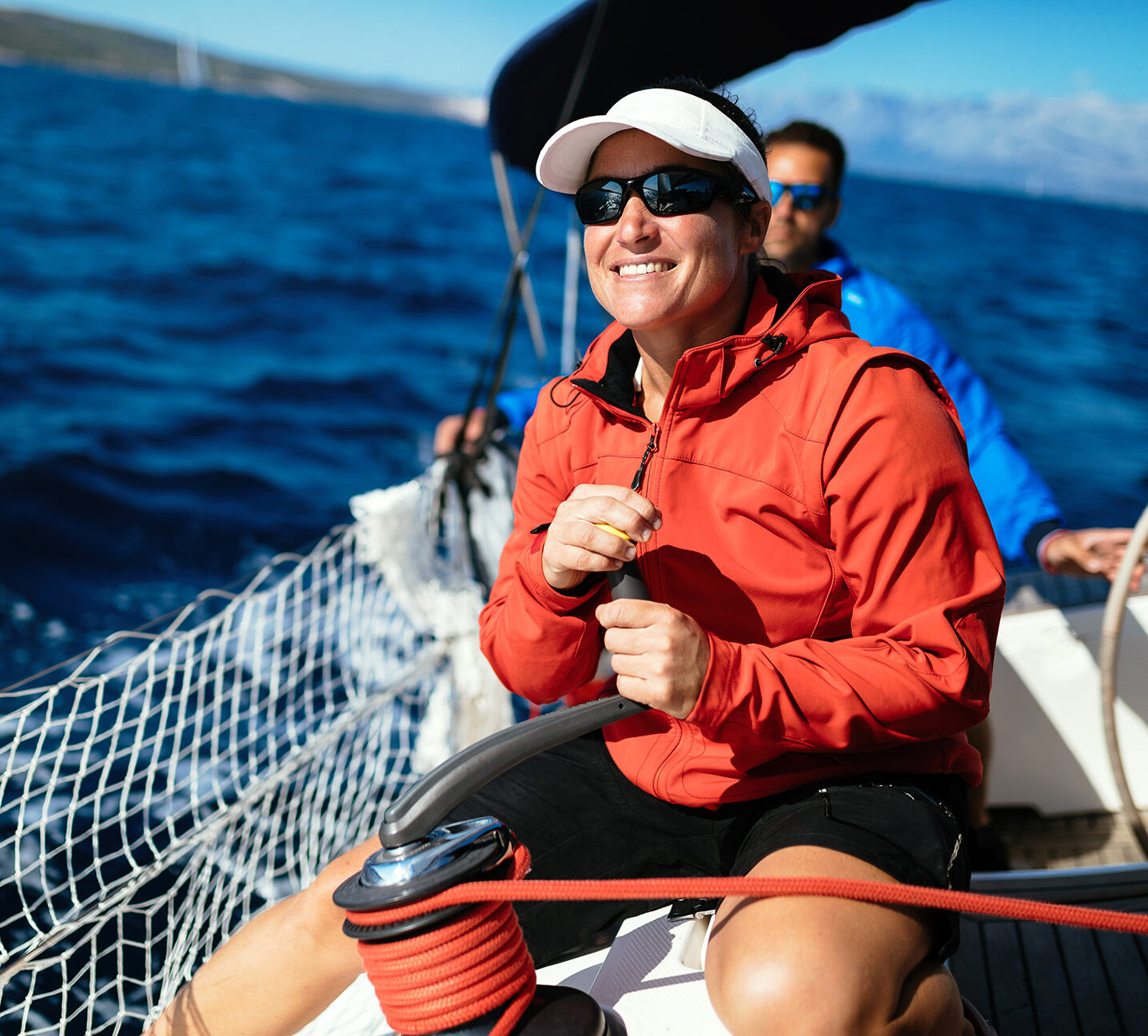 A woman smiling as she sails her sail boat, after using PACU for her boat, RV, or motorcycle loan