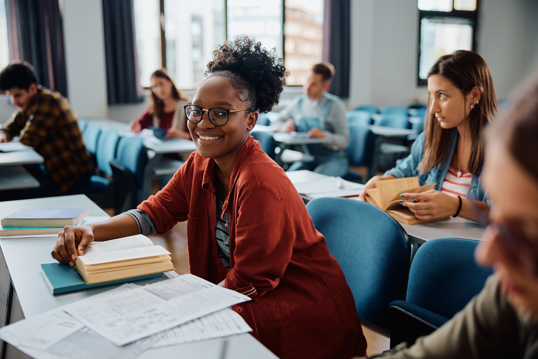 woman in a class during a college lecture studying her notes