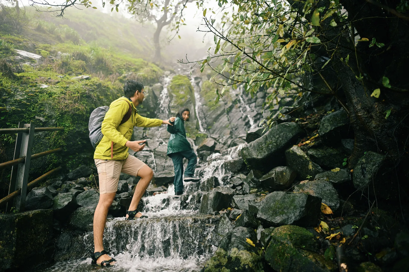 A couple hikes a waterfall together on their vacation